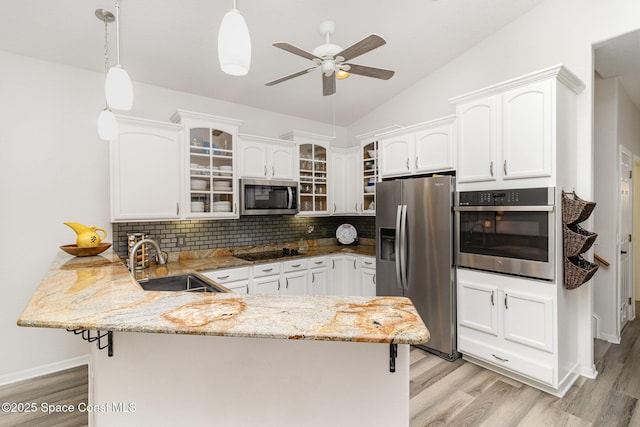 142 Ocean Garden Ln, Cape Canaveral, FL 32920 - kitchen with appliances with stainless steel finishes, a peninsula, ceiling fan, light stone countertops, and glass insert cabinets