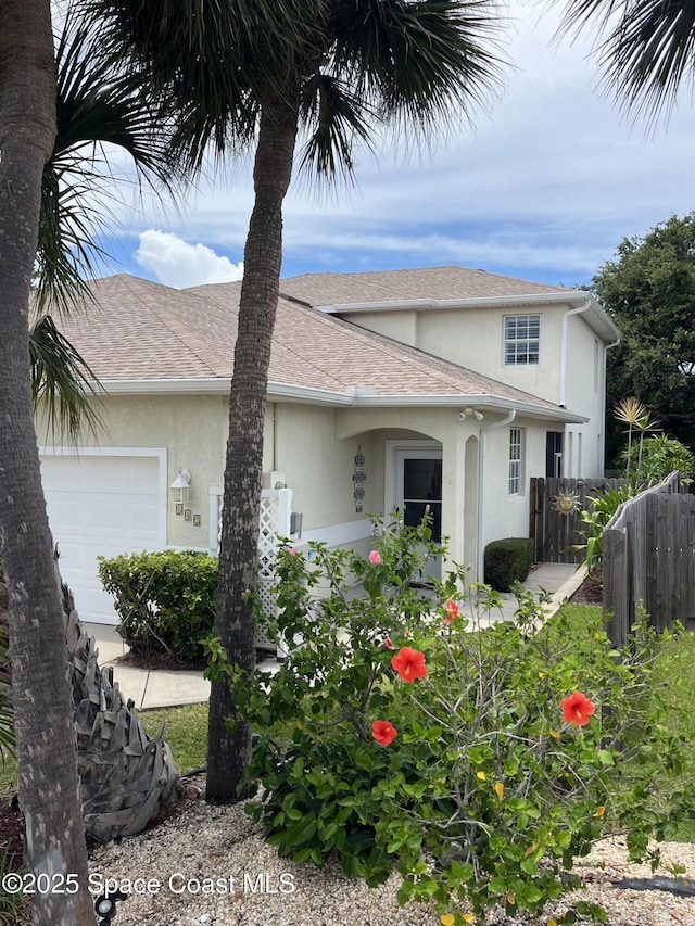 142 Ocean Garden Ln, Cape Canaveral, FL 32920 - view of side of property with stucco siding, an attached garage, and a shingled roof