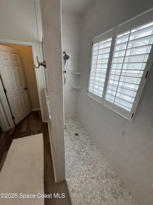 142 Ocean Garden Ln, Cape Canaveral, FL 32920 - bathroom with a tile shower and wood finished floors