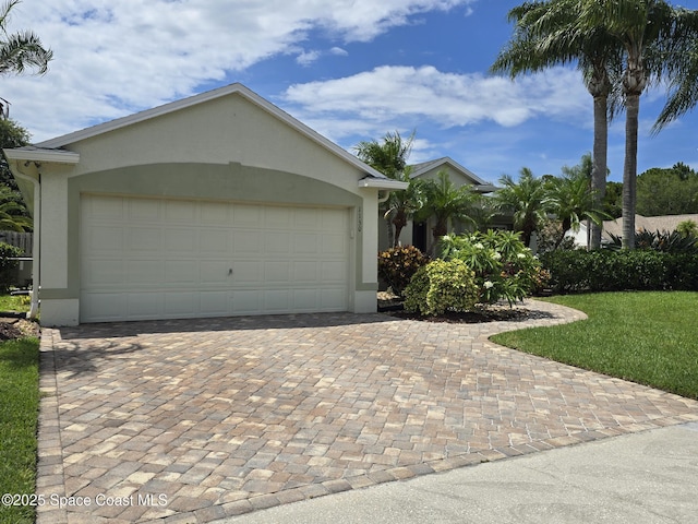 1150 Ida Way, Melbourne, FL 32940 - view of front of property featuring stucco siding, decorative driveway, and an attached garage