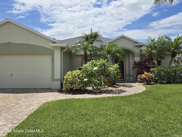 1150 Ida Way, Melbourne, FL 32940 - ranch-style home featuring stucco siding, a garage, a front lawn, and decorative driveway