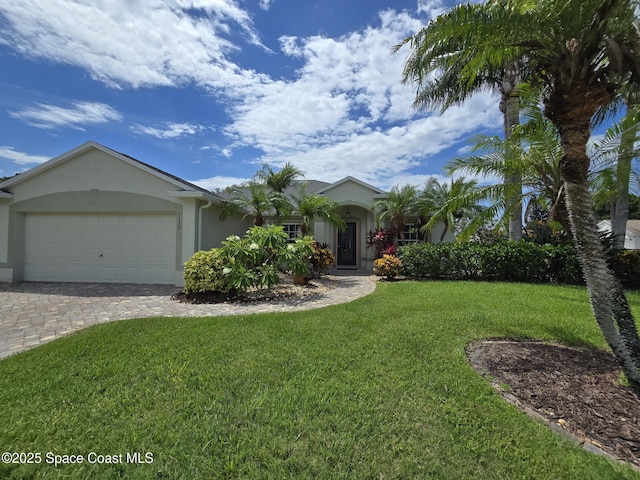 1150 Ida Way, Melbourne, FL 32940 - view of front of home with stucco siding, a front lawn, a garage, and driveway