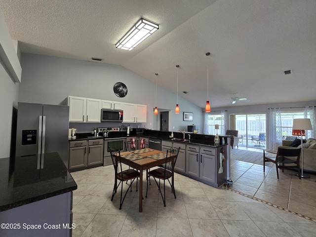 1150 Ida Way, Melbourne, FL 32940 - kitchen with appliances with stainless steel finishes, a peninsula, dark countertops, open floor plan, and light tile patterned flooring