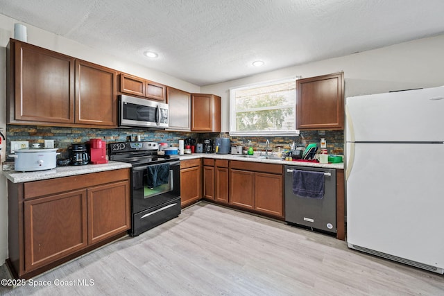 1620 Wichita Blvd SE, Palm Bay, FL 32909 - kitchen with appliances with stainless steel finishes, a sink, light countertops, light wood finished floors, and a textured ceiling