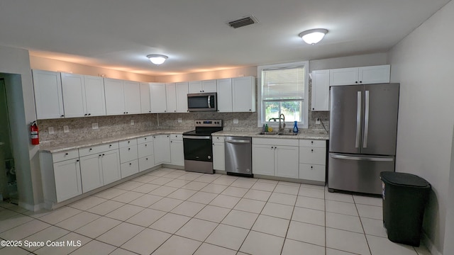 1620 Wichita Blvd SE, Palm Bay, FL 32909 - kitchen with appliances with stainless steel finishes, a sink, decorative backsplash, and white cabinets