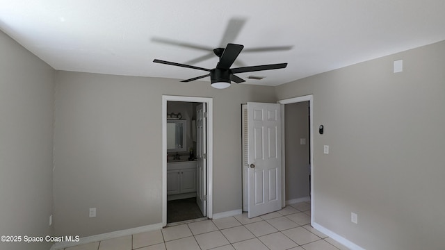 1620 Wichita Blvd SE, Palm Bay, FL 32909 - unfurnished bedroom featuring light tile patterned floors, baseboards, ensuite bath, and ceiling fan