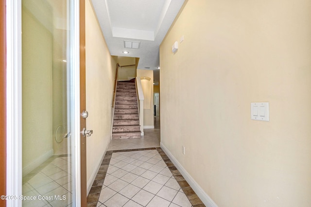 2178 Tanager Ct, Melbourne, FL 32903 - hall featuring light tile patterned floors, stairs, baseboards, and a tray ceiling