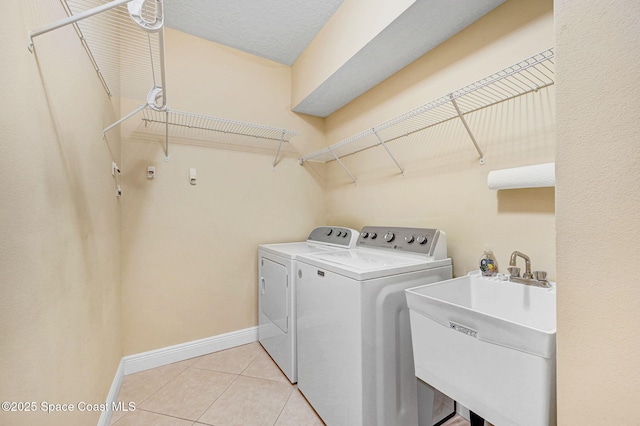 2178 Tanager Ct, Melbourne, FL 32903 - laundry area featuring washer and dryer, baseboards, and light tile patterned floors