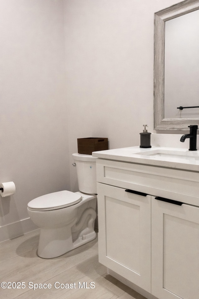 2148 Country Club Rd, Melbourne, FL 32901 - bathroom with toilet, vanity, and baseboards