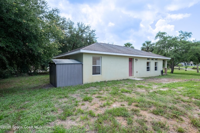4180 Seville Ave, Cocoa, FL 32926 - back of property with a storage shed, stucco siding, and a lawn