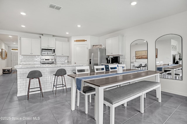 1265 Valley View Ave, Rockledge, FL 32955 - kitchen with appliances with stainless steel finishes, white cabinetry, decorative backsplash, light countertops, and recessed lighting
