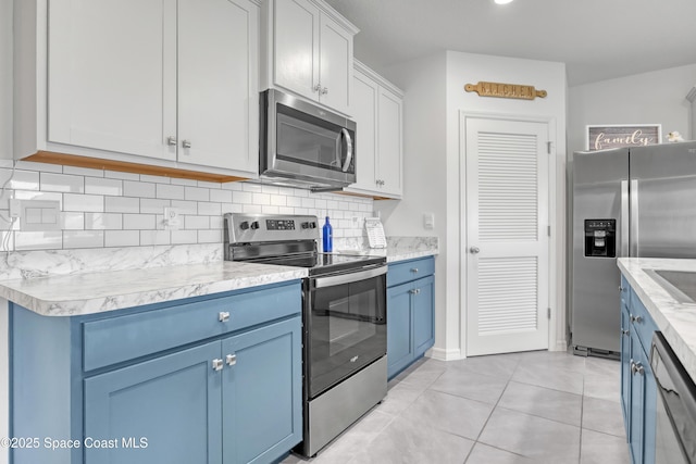 1265 Valley View Ave, Rockledge, FL 32955 - kitchen featuring stainless steel appliances, blue cabinets, decorative backsplash, light countertops, and light tile patterned floors