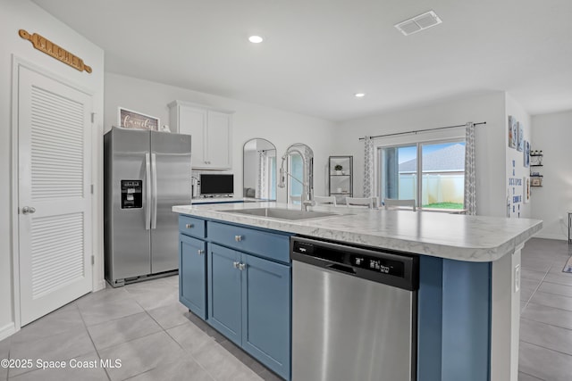1265 Valley View Ave, Rockledge, FL 32955 - kitchen with appliances with stainless steel finishes, light countertops, light tile patterned floors, blue cabinetry, and a kitchen island with sink