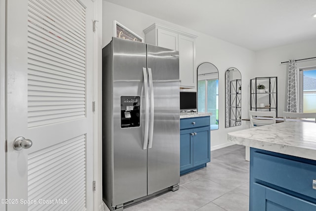 1265 Valley View Ave, Rockledge, FL 32955 - kitchen featuring stainless steel fridge with ice dispenser, blue cabinets, light countertops, and light tile patterned flooring