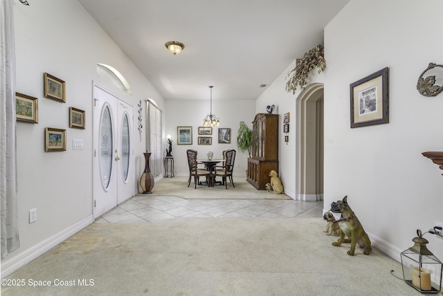 386 Valencia Rd, Melbourne, FL 32904 - tiled foyer entrance with carpet flooring and a chandelier