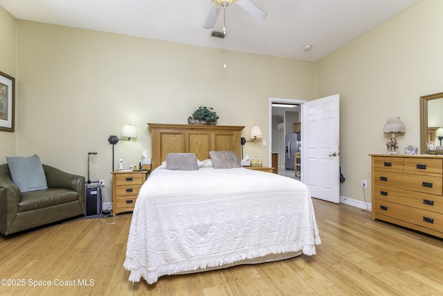 386 Valencia Rd, Melbourne, FL 32904 - bedroom with light wood-style flooring, stainless steel fridge with ice dispenser, and a ceiling fan