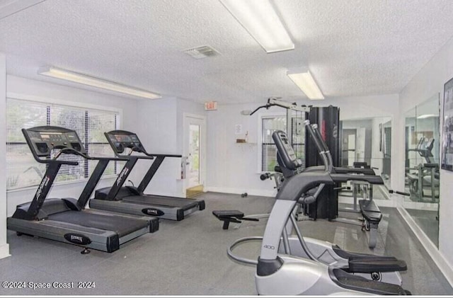 225 S Tropical Trl Unit 607, Merritt Island, FL 32952 - workout area featuring a textured ceiling and baseboards