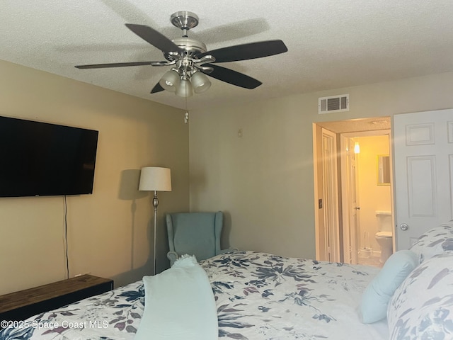 225 S Tropical Trl Unit 607, Merritt Island, FL 32952 - bedroom featuring ceiling fan, a textured ceiling, and ensuite bath