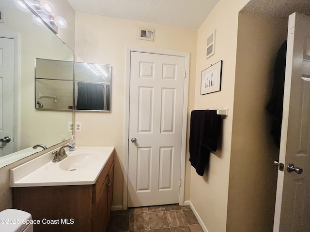 225 S Tropical Trl Unit 607, Merritt Island, FL 32952 - bathroom featuring vanity, baseboards, and toilet