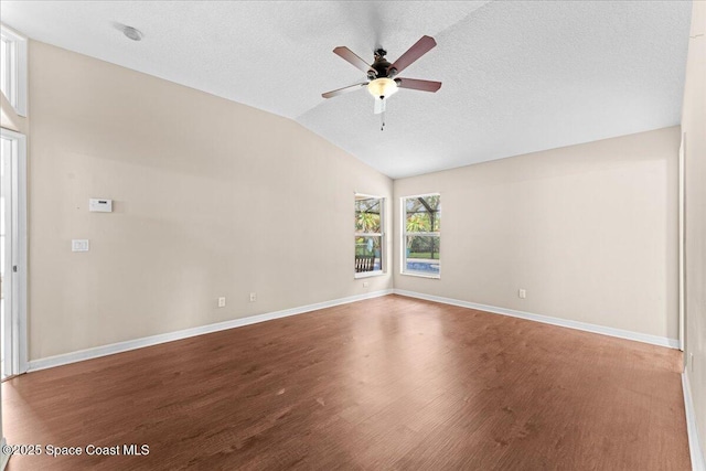 1211 Olde Bailey Ln, Melbourne, FL 32904 - empty room featuring wood finished floors, vaulted ceiling, ceiling fan, and a textured ceiling