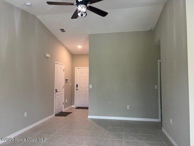 465 Hatcher St SE, Palm Bay, FL 32909 - empty room with a ceiling fan, tile patterned flooring, baseboards, and a smoke detector