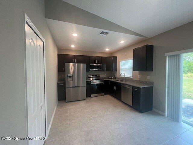 465 Hatcher St SE, Palm Bay, FL 32909 - kitchen featuring stainless steel appliances, plenty of natural light, baseboards, lofted ceiling, and recessed lighting