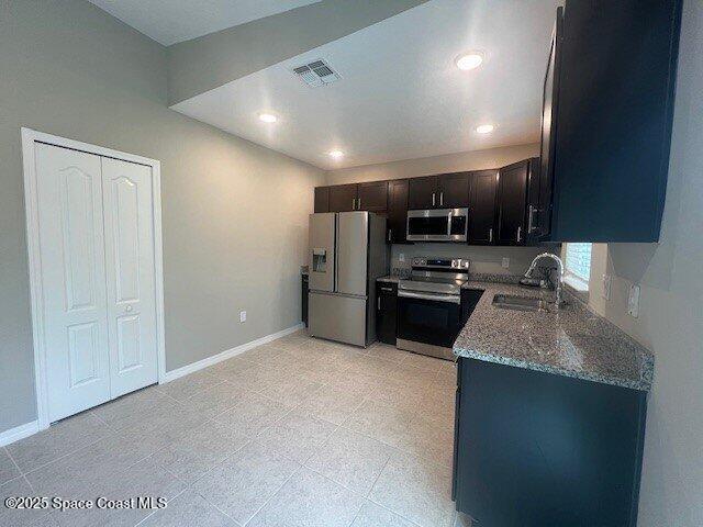 465 Hatcher St SE, Palm Bay, FL 32909 - kitchen with stainless steel appliances, a sink, stone countertops, baseboards, and recessed lighting