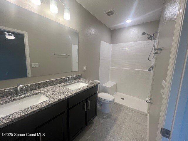 465 Hatcher St SE, Palm Bay, FL 32909 - full bathroom featuring toilet, a tile shower, and double vanity
