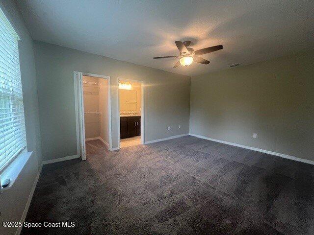 465 Hatcher St SE, Palm Bay, FL 32909 - unfurnished bedroom with baseboards, carpet floors, multiple windows, and ensuite bathroom