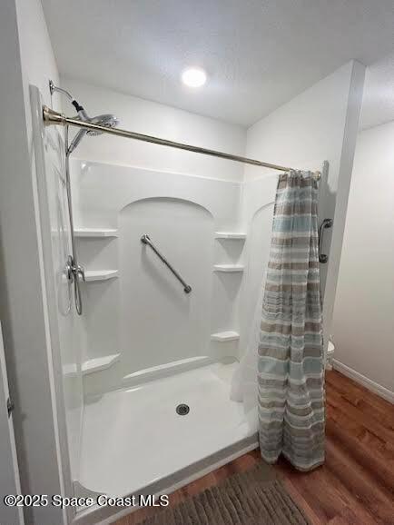 1119 Blossom Dr, Sebastian, FL 32958 - full bathroom with a stall shower, wood finished floors, and baseboards
