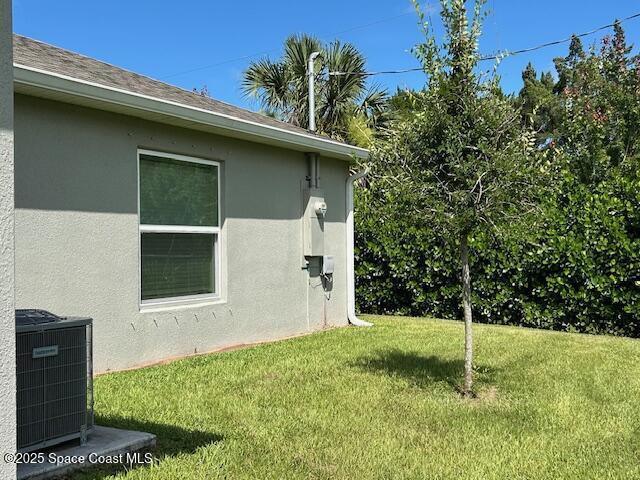 1119 Blossom Dr, Sebastian, FL 32958 - view of property exterior featuring a lawn and stucco siding