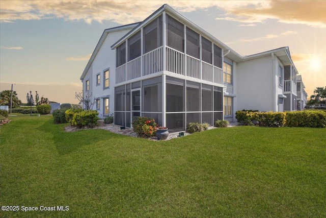 530 S Brevard Ave Unit 315, Cocoa Beach, FL 32931 - rear view of house with stucco siding, a yard, and a sunroom