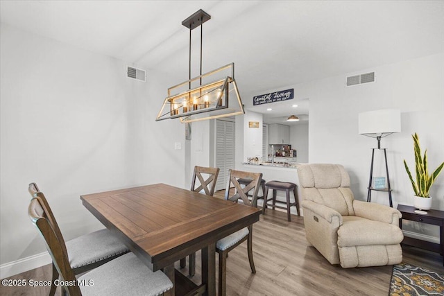 530 S Brevard Ave Unit 315, Cocoa Beach, FL 32931 - dining area featuring wood finished floors and a chandelier