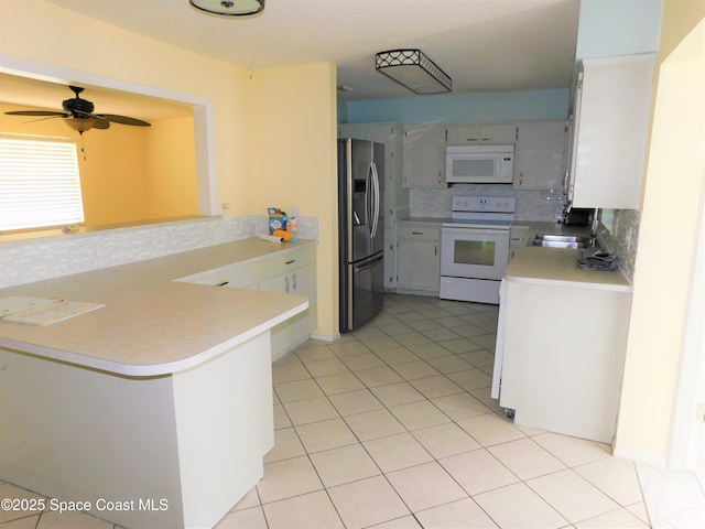 220 Maureen Ave, Merritt Island, FL 32953 - kitchen featuring white appliances, tasteful backsplash, a peninsula, a ceiling fan, and light countertops