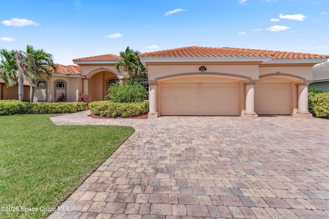 3631 Thurloe Dr, Rockledge, FL 32955 - mediterranean / spanish house with stucco siding, decorative driveway, an attached garage, a front lawn, and a tiled roof