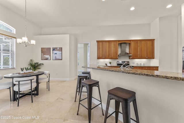 3631 Thurloe Dr, Rockledge, FL 32955 - kitchen with wall chimney range hood, stainless steel range with electric cooktop, a chandelier, brown cabinets, and a kitchen bar