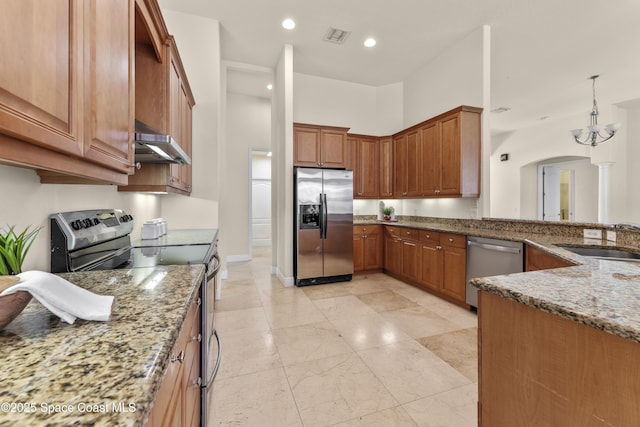 3631 Thurloe Dr, Rockledge, FL 32955 - kitchen with appliances with stainless steel finishes, a sink, under cabinet range hood, light stone countertops, and decorative light fixtures