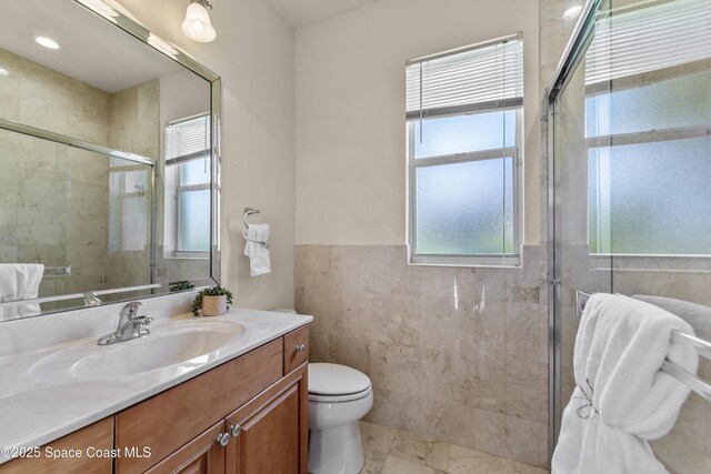 3631 Thurloe Dr, Rockledge, FL 32955 - full bathroom with tile walls, healthy amount of natural light, vanity, a stall shower, and toilet
