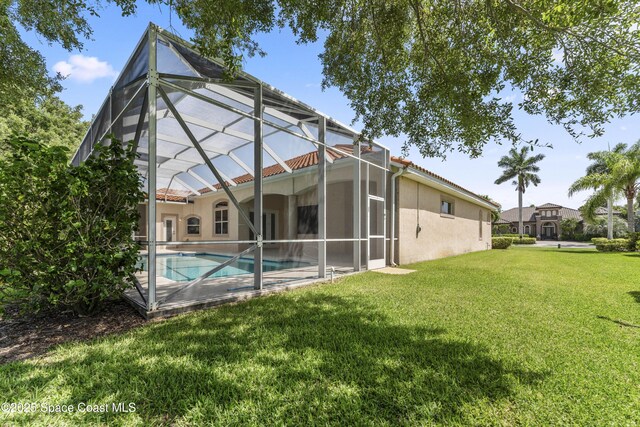 3631 Thurloe Dr, Rockledge, FL 32955 - back of house featuring a yard, stucco siding, an outdoor pool, and glass enclosure