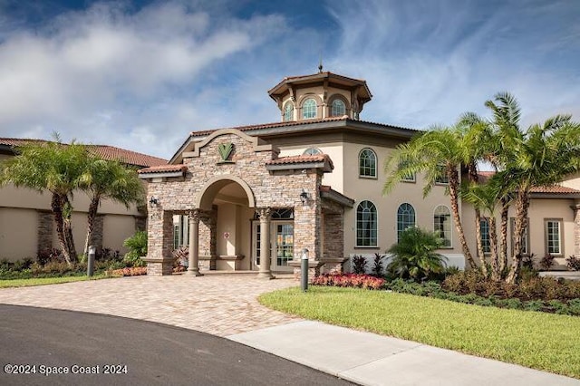 2365 Reeling Cir, Melbourne, FL 32940 - view of front of property featuring stucco siding, decorative driveway, a front yard, stone siding, and a tiled roof