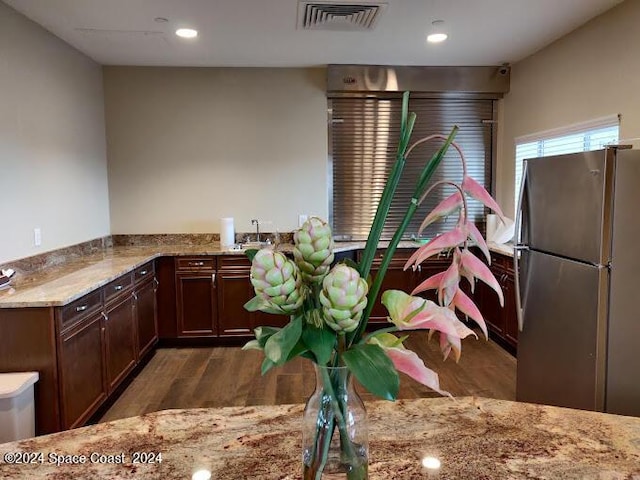 2365 Reeling Cir, Melbourne, FL 32940 - kitchen featuring freestanding refrigerator, wood finished floors, light stone counters, dark brown cabinetry, and recessed lighting