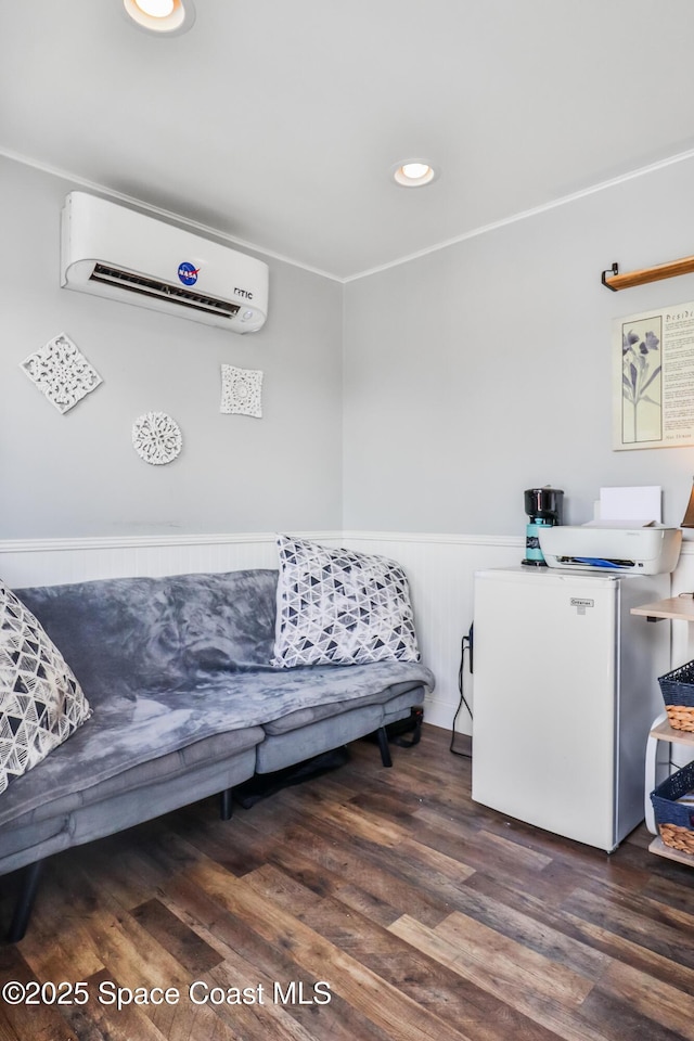 348 Berkeley St, Satellite Beach, FL 32937 - sitting room featuring an AC wall unit, wainscoting, wood finished floors, and recessed lighting
