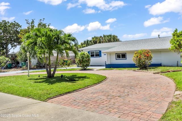 348 Berkeley St, Satellite Beach, FL 32937 - ranch-style house featuring curved driveway, a front lawn, stucco siding, and roof with shingles