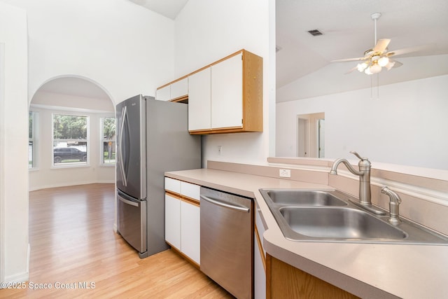 6856 Buxton Ave, Cocoa, FL 32927 - kitchen with appliances with stainless steel finishes, light wood finished floors, lofted ceiling, white cabinets, and light countertops