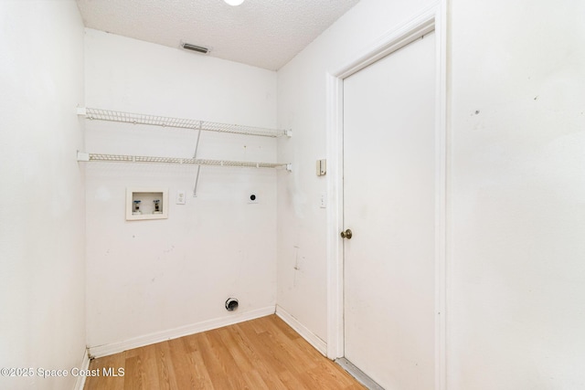 6856 Buxton Ave, Cocoa, FL 32927 - washroom featuring electric dryer hookup, washer hookup, light wood-style flooring, and a textured ceiling