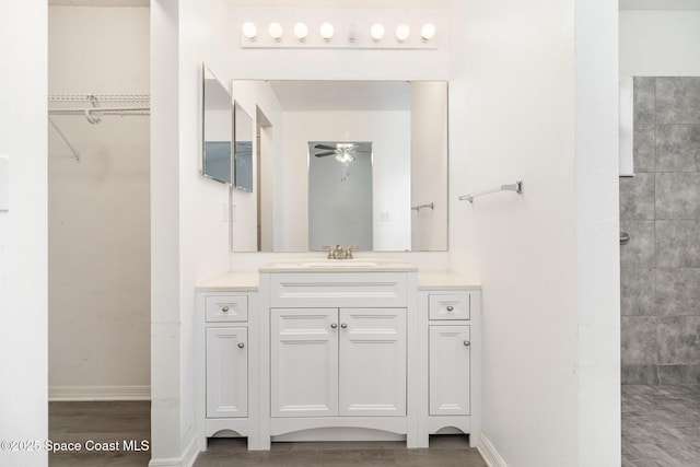 6856 Buxton Ave, Cocoa, FL 32927 - full bathroom with ceiling fan, vanity, wood finished floors, tiled shower, and a spacious closet