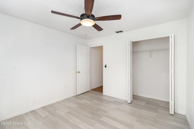 6856 Buxton Ave, Cocoa, FL 32927 - unfurnished bedroom with light wood-type flooring, a closet, a ceiling fan, and a textured ceiling
