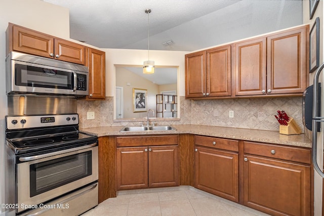1265 Helias St NW, Palm Bay, FL 32907 - kitchen with stainless steel appliances, a sink, brown cabinets, and vaulted ceiling