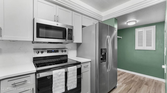 1420 Huntington Ln Unit 2405, Rockledge, FL 32955 - kitchen featuring appliances with stainless steel finishes, light countertops, light wood-style floors, and a textured ceiling