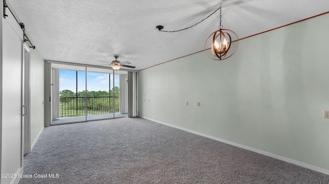 1420 Huntington Ln Unit 2405, Rockledge, FL 32955 - carpeted empty room featuring a wall of windows, ceiling fan, a textured ceiling, and a barn door